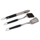 Stainless steel tongs, spatula and grill brush with black handles, shown on a white background.