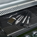 Five-piece barbecue tool set laid on cast iron grill grates inside an open barbecue.