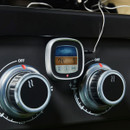 Digital probe thermometer clipped to the front of a barbecue, cable leading to the temperature probe.