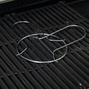 Folded stainless steel beer can chicken roaster lying on barbecue grill grates.