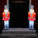 Two lit nutcrackers in front of a dark doorway