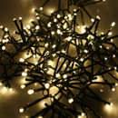 Illuminated warm white cluster string lights bundled together, highlighting the dense LED arrangement and soft festive glow.