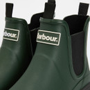 Close-up of green Barbour Chelsea wellies highlighting the rubber logo badge and elasticated side panel.