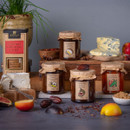 Cheese Lovers Preserves gift set displayed with farmhouse chutney, sticky fig preserve, tomato and chilli relish, ploughman’s chutney, and oatcakes, styled with cheese, fresh fruit, and spices on a rustic table.