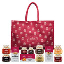 Mrs Bridges gift set featuring a red reusable bag with jar illustrations, displayed with an assortment of mini preserves, marmalades, chutneys, clotted cream fudge, and shortbread boxes arranged in front.