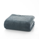 A rolled up grey blanket throw on a white background