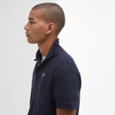 Side profile of a person wearing a dark blue polo shirt with a raised collar, set against a plain white background. The expression is neutral.