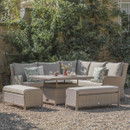 Outdoor patio setup with wicker furniture, cushions, and a table with flowers on a gravel surface.