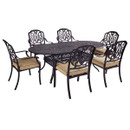 A six-seater cast aluminium outdoor dining set featuring an ornate oval table with an intricate lattice design and six matching armchairs with decorative scroll backs and taupe seat cushions.