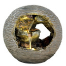 A spherical stone fountain with a hollow center features cascading water over golden rocks, creating a serene and natural ambiance.