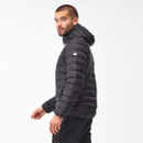 Man in a black quilted puffer jacket with a hood, looking back over his shoulder. The background is a light, neutral tone, creating a calm mood.