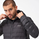 Man adjusting the hood of a black puffer jacket against a plain background. His expression is focused, showcasing the jacket's quilted texture.