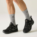 Man wearing black waterproof hiking trainers with grey detailing and durable grip soles, paired with grey walking socks.