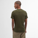 A person stands with their back to the camera, wearing an olive green t-shirt and khaki pants against a plain white background, conveying a casual look.