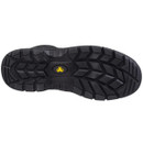 Bottom view of a black work boot sole with deep tread pattern and yellow safety logo at the centre.