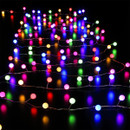 Multicoloured globe LED string lights arranged across a dark surface, featuring red, blue, green, yellow and pink illuminated bulbs for vibrant Christmas and party decorations.