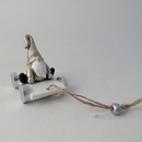 A hanging decoration that is a gonk on a grey sledge.