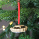A view of a ceramic mince pie hanging Christmas decoration on a Christmas tree