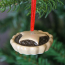 A close up view of a ceramic mince pie hanging Christmas decoration on a Christmas tree
