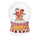 A decorated gingerbread snow globe with a gingerbread family and snow floating around.