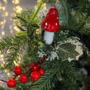 Festive ornament on a Christmas tree branch; features a red and white mushroom with sprigs of artificial greenery and red berries, warm lights softly glowing. Festive ornament on a Christmas tree branch; features a red and white mushroom with sprigs of artificial greenery and red berries, warm lights softly glowing.