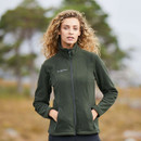 Person with curly hair standing outdoors wearing a green fleece.