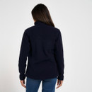 Back view of a women’s navy fleece jacket with high collar, styled with blue jeans.