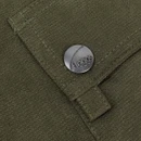 Close-up of a dark olive green pocket flap, showing textured fabric, stitching and a metal press stud embossed with the Hoggs name.