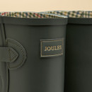 Close-up of the top of green Joules Wellington boots showing buckle strap and heritage check lining, and Joules logo