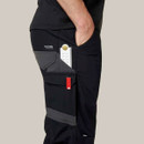 Close-up of ruler and tool stored in side pocket of black work trousers with reinforced fabric