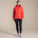 Full-length view of a model wearing women's black high-waisted performance leggings with a red insulated jacket and walking shoes, showcasing an outdoor active outfit.
