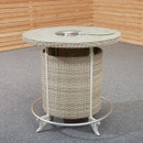 Round wicker bar table with a light grey top and metal accents, set against a wooden panelled wall and gray carpet, creating a rustic ambiance.