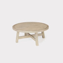 A round wooden outdoor coffee table with a natural finish, displayed against a clean white backdrop.