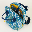 Blue floral backpack with yellow interior and blue straps against a white background.