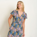 Woman in a floral dress against a plain background.