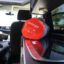 Red rolled-up camping gear labelled "Vango Poptop 5CM" inside a van, placed on a reflective surface. The interior is bright and modern, suggesting travel.