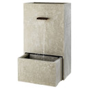 Tall, rectangular stone water fountain with water cascading from a spout into a square basin below. Minimalist, earthy tone, evokes tranquillity.