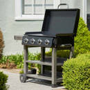 Angled view of the BBQ with the lid open, shown on a patio outside a house.