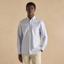 Men’s light blue Oxford button-down shirt with chest pocket, styled with beige chinos against a neutral background