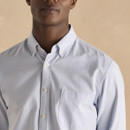 Close-up of light blue Oxford shirt featuring button-down collar and chest pocket detail