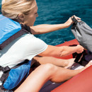 Person loading gear into Intex Excursion Pro K2 inflatable kayak on the water