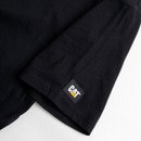 Close-up of the CAT logo tag on the sleeve hem of the black T-shirt.