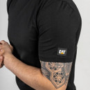 Close-up of a person wearing the black CAT short sleeve T-shirt showing the sleeve logo and arm detail.