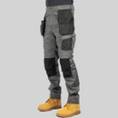 Angled side view of grey CAT work trousers showing holster pockets, cargo pockets and reinforced knee panels