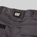 Close-up of CAT logo on grey work trousers waistband with reinforced seams and belt loops