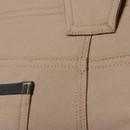 Detail of beige work trousers fabric showing reinforced seams, stitching and durable ripstop material