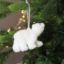 A view of a polar bear hanging decoration hanging on a Christmas tree