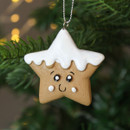 A close up view of a ceramic Gingerbread Star with Smiley Face Hanging Decoration hanging on a Christmas tree