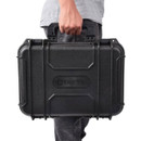 A person holds a sturdy black hard-shell case labelled "TACTIX" by the handle. The case appears durable, suggesting protection and security.