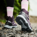 A person wearing a pair of purple walking boots